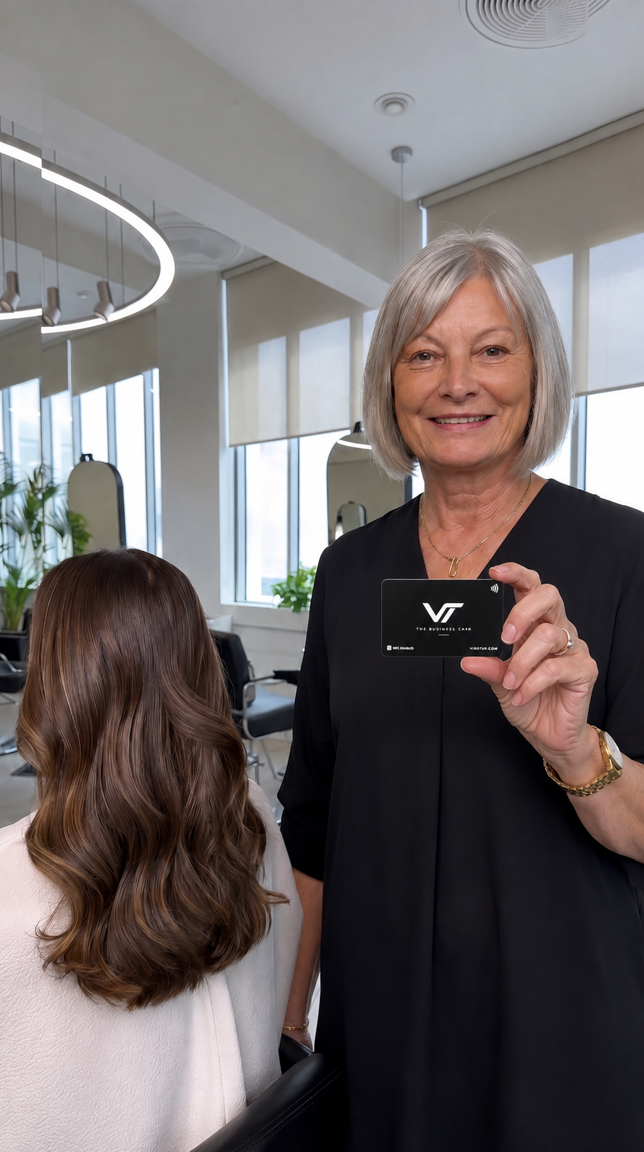 Hair salon owner holding the Viro Tap metal NFC business card