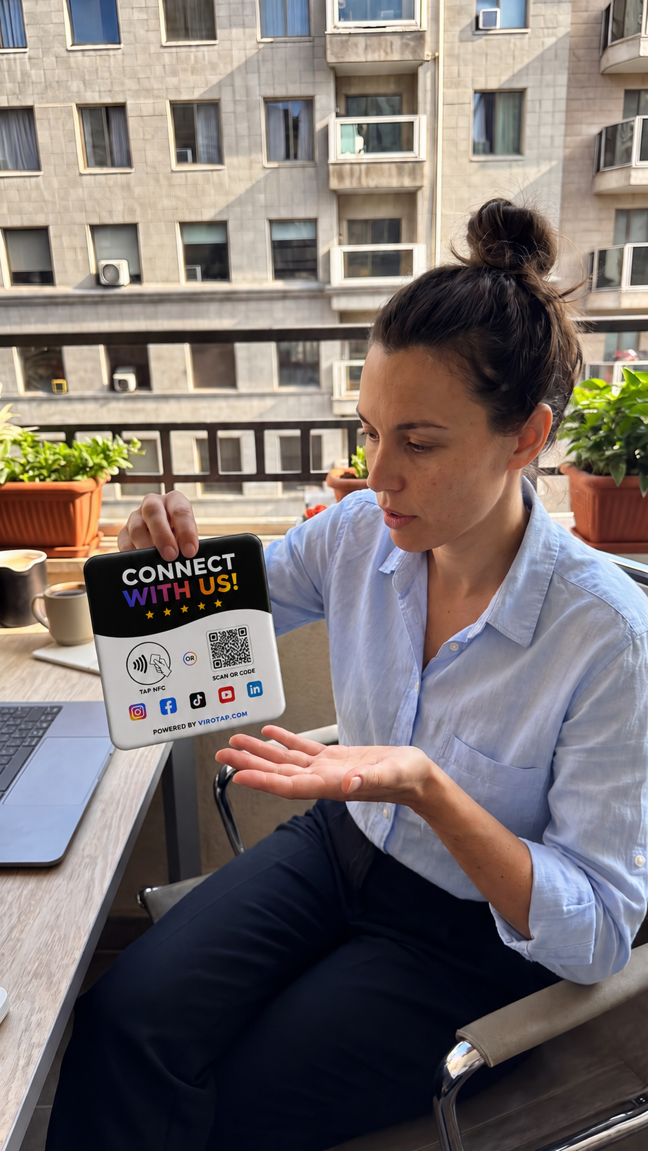 Office worker holding a Viro Tap Connect With Us NFC sign