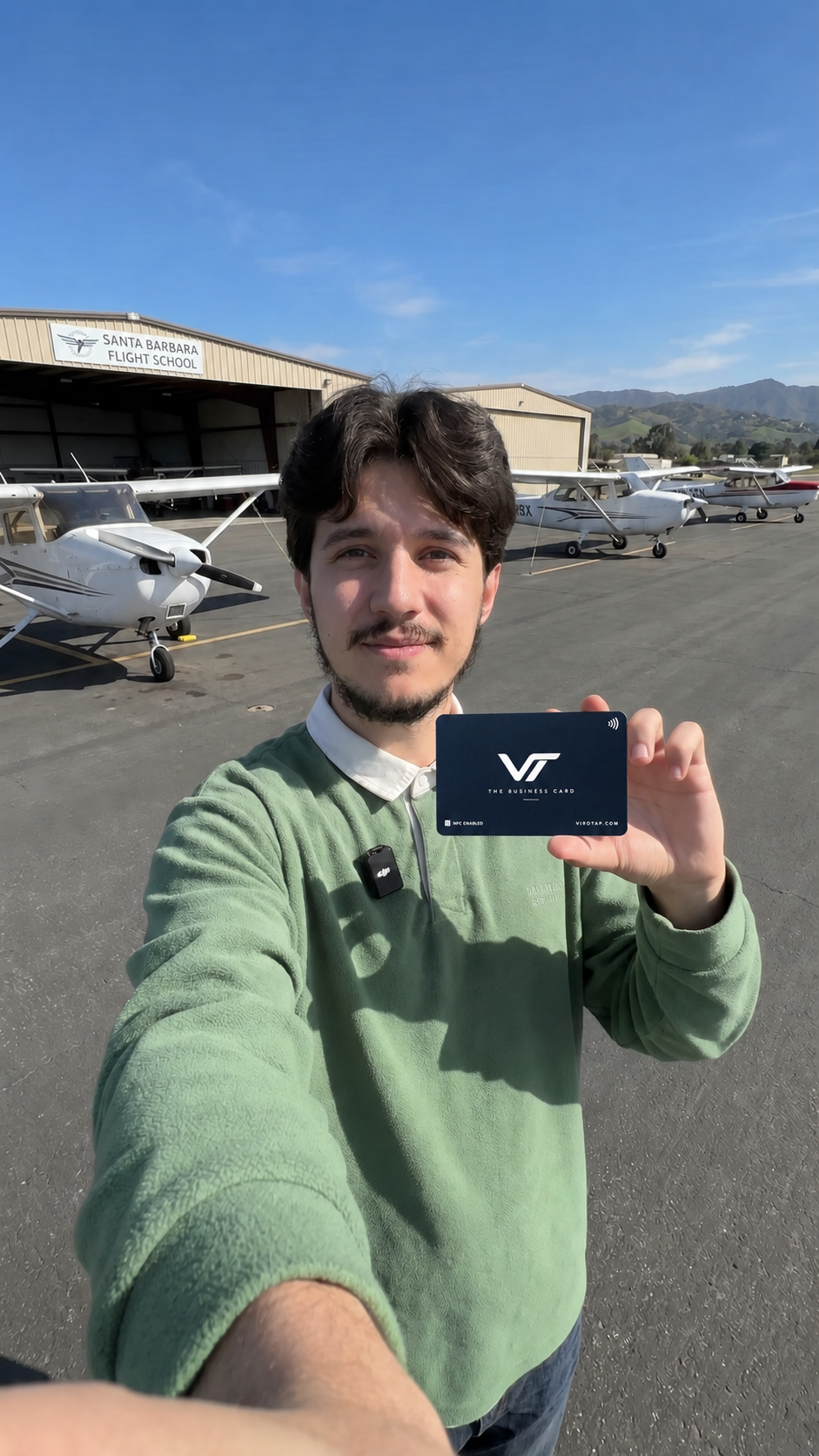 Flight school instructor holding the Viro Tap metal NFC business card